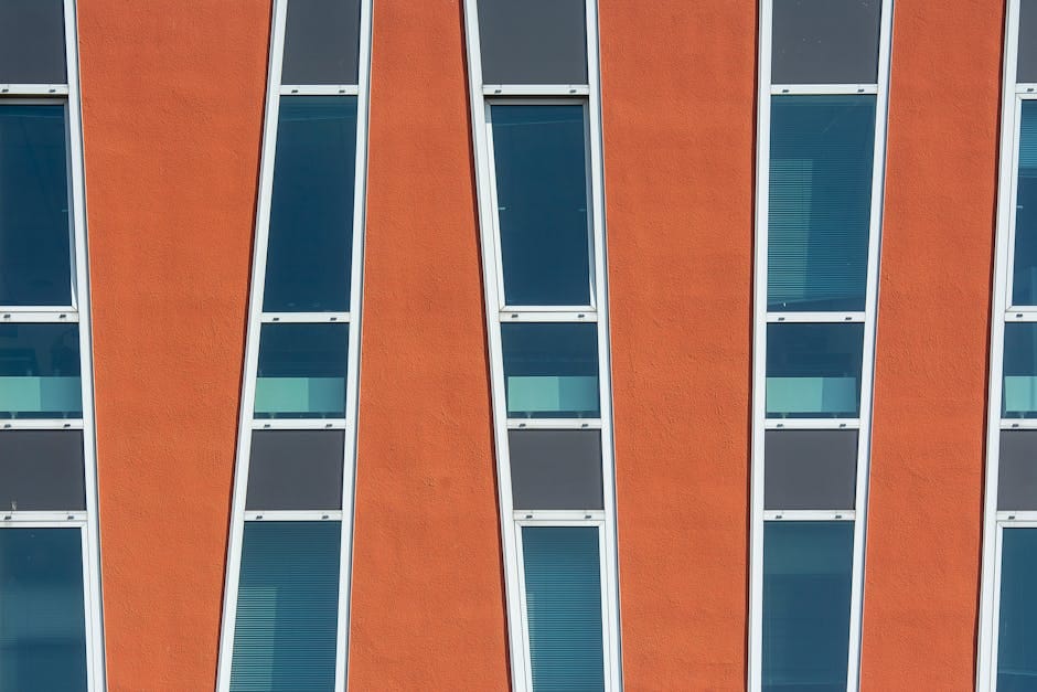 Close-up of a building facade showcasing modern geometric patterns and striking orange color.